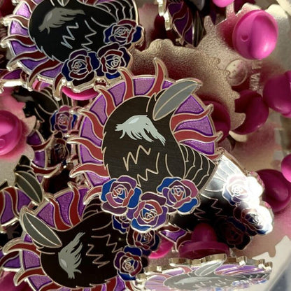 The photo shows a dozen or so pins in this design and also shows the back of the pin has the shop logo on and two purple round rubber clutches on the sides.