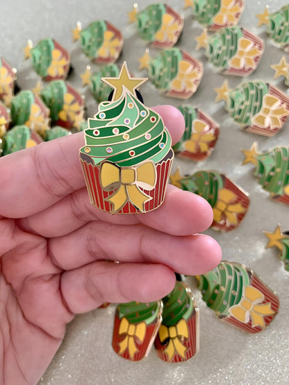 The image shows a hand holding one of the cupcake pins.