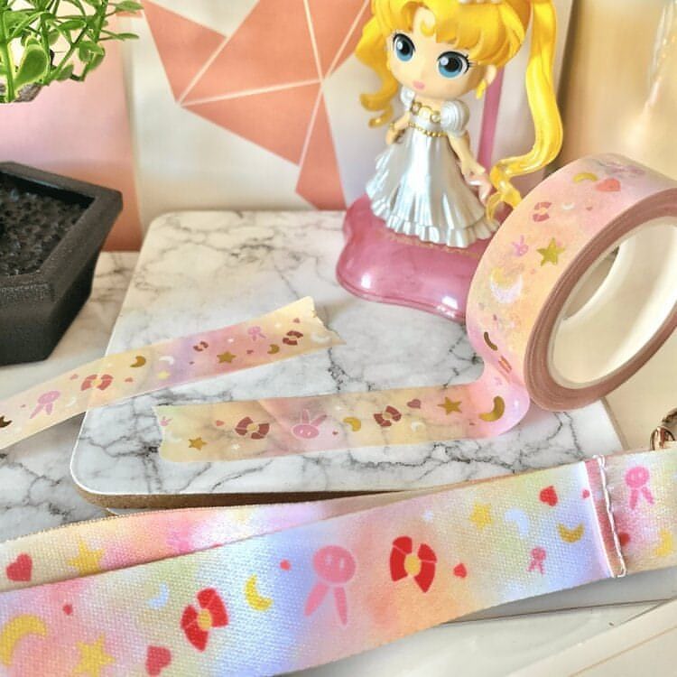 The image shows a miniature sailor moon figurine in the background, the anime style washi tape in the middle of the photo, and a close up of the pattern on the lanyard at the front and bottom of the photo.
